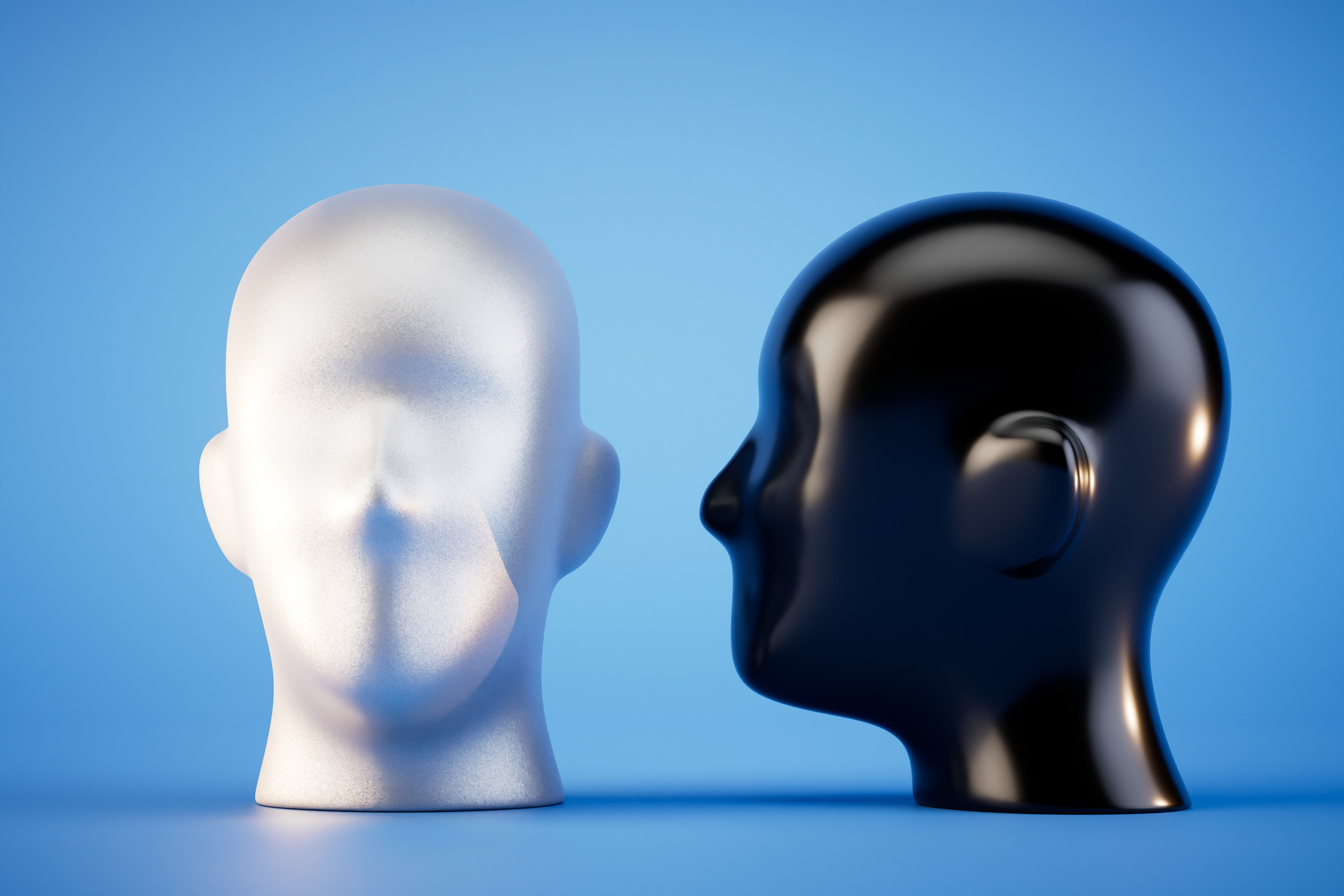 Two abstract mannequin heads on a blue background: one is metallic silver with a distorted face, the other is smooth and shiny black, shown in profile facing the silver head.